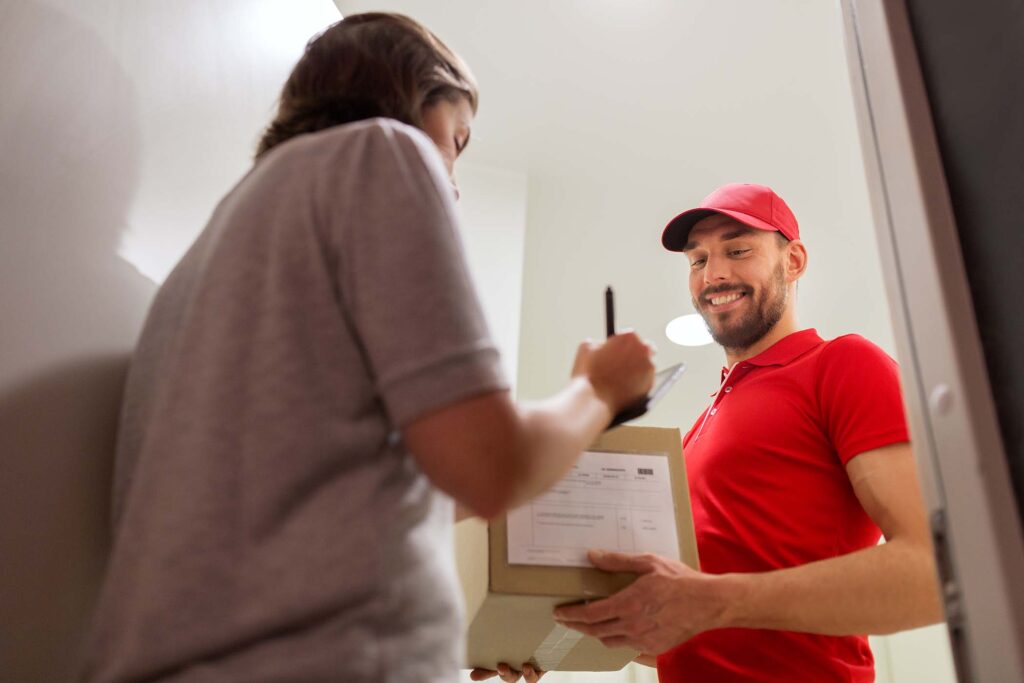 deliveryman-and-customer-with-parcel-boxes-at-home-P779P2W.jpg
